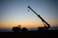 Abstract Industrial background with construction crane silhouette over amazing sunset sky. Mobile crane against the evening sky. Royalty Free Stock Photo