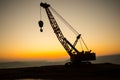Abstract Industrial background with construction crane silhouette over amazing sunset sky. Tower crane against the evening sky. Royalty Free Stock Photo