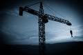 Abstract Industrial background with construction crane silhouette over amazing sunset sky. Tower crane against the evening sky. Royalty Free Stock Photo