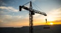 Abstract Industrial background with construction crane silhouette over amazing sunset sky. Tower crane against the evening sky. Royalty Free Stock Photo