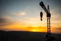 Abstract Industrial background with construction crane silhouette over amazing sunset sky. Tower crane against the evening sky. Royalty Free Stock Photo