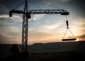 Abstract Industrial background with construction crane silhouette over amazing sunset sky. Tower crane against the evening sky. Royalty Free Stock Photo