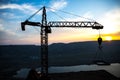 Abstract Industrial background with construction crane silhouette over amazing sunset sky. Tower crane against the evening sky. Royalty Free Stock Photo