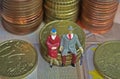 Abstract isolated figures of a retired old couple sitting on a stack of euro coins money - pension and retirement savings concept Royalty Free Stock Photo