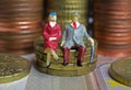 Abstract isolated figures of a retired old couple sitting on a stack of euro coins money - pension and retirement savings concept Royalty Free Stock Photo