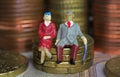 Abstract isolated figures of a retired old couple sitting on a stack of euro coins money - pension and retirement savings concept Royalty Free Stock Photo