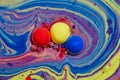 Abstract jaw breaker red, blue, yellow orbs of oil in colorful swirling sea of purple art asset Royalty Free Stock Photo