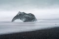 An abstract large piece of glacier ice sits on a black sand beach in Iceland