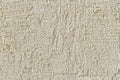 Abstract light beige grainy background with the texture of coarse grained new decorative plaster. Construction and repair. Royalty Free Stock Photo