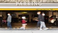 Abstract long exposure blurred photo of people walking on the street by parking area