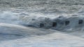 Abstract long exposure landscape image of waves crashing onto groynes on beach during sunset