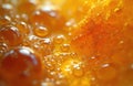 Abstract macro photo shows many small, large orange bubbles on liquid surface. Smooth wet texture reflects bright light, creating Royalty Free Stock Photo