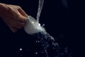 Abstract, man hand with cleaning coffee cup of the water splash on dark background, soft focus