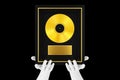 Abstract Mannequin Hands Holding Gold Vinyl or CD Prize Award with Label in Black Frame. 3d Rendering