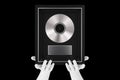 Abstract Mannequin Hands Holding Platinum or Silver Vinyl or CD Prize Award with Label in Black Frame. 3d Rendering Royalty Free Stock Photo