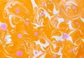 Abstract marbling ebru colorful orange background with waves and pink blots