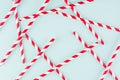 Abstract modern fashion background - red and white striped straws as random pattern on light mint background. Royalty Free Stock Photo