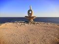 Abstract modern sculpture called "A wise man" on a sea cliff, Crimea.