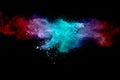Abstract multicolored powder explosion on black background. Red and blue dust particles splattered on background Royalty Free Stock Photo