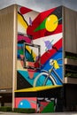 Abstract mural featuring an array of vibrant colors and shapes painted on an exterior wall