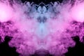 Abstract mystical bat silhouette straightened wings and head from streams of colorful smoke evaporating from a vape illuminated by Royalty Free Stock Photo