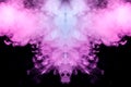 Abstract mystical bat silhouette straightened wings and head from streams of colorful smoke evaporating from a vape illuminated by Royalty Free Stock Photo