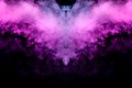 Abstract mystical bat silhouette straightened wings from streams of colorful smoke evaporating from a vape illuminated by neon Royalty Free Stock Photo