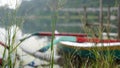 Abstract nature background. Blurry background of the colorful wooden fishing boats floating on lake behind the wild green grass Royalty Free Stock Photo