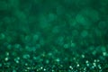 Abstract New Year emerald bokeh background with shining defocus sparkles. Blurred glitters shimmering dust macro close up, copy