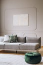 Abstract painting on grey wall with moldings in contemporary living room interior with grey long couch Royalty Free Stock Photo