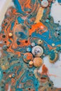 Abstract oil spill acrylic painting with swirling orange blue gold and white bubbles and spheres in marble like