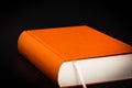 Abstract orange colored book on a black background