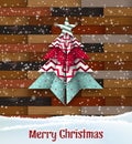 Abstract origami christmas tree on wooden background