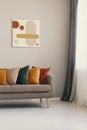 Painting on beige wall above brown sofa with colorful pillows Royalty Free Stock Photo