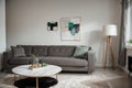 Abstract painting on grey wall o contemporary living room interior with emerald green armchair with round pillow, commode and couc Royalty Free Stock Photo