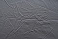 Abstract pattern of a gray crumpled bed sheet in bedroom. Gray wrinkled fabric texture rippled surface, Close up bed sheet in the