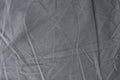 Abstract pattern of a gray crumpled bed sheet in bedroom. Gray wrinkled fabric texture rippled surface, Close up bed sheet in the
