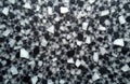 Abstract pattern of irregular black and white fragments on a speckled grey surface. The textured mosaic creates a modern graphic Royalty Free Stock Photo