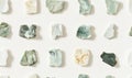 Abstract pattern of various colored and shaped stone fragments arranged in a grid on a white background Royalty Free Stock Photo