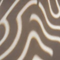 Abstract pattern of wavy, cream-colored lines against a light brown backg Royalty Free Stock Photo