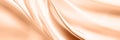 Abstract peach silk fabric texture background. Peach Fuzz color of the year 2024. Elegant luxury satin cloth with wave