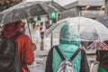 Abstract people under umbrellas. Rainy evening in city street at autumn. Seasons, weather