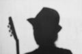 Abstract person silhouette in hat and with guitar on grey background, music concept. Black and white. Acoustic guitarist. Hobby, Royalty Free Stock Photo