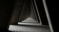 Abstract Perspective of a Dark, Triangular Tunnel with Cracked Ground and Dramatic Lighting corridor Royalty Free Stock Photo