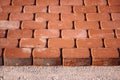 Brown concrete permeable flooring assembled on a substrate of sand. Abstract photo of bricks in the sunlight