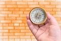 Abstract photo with compass in hand on brick wall background