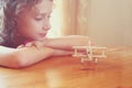 Abstract photo of cute kid looking at old wooden plane. selective focus. inspiration and childhood concept