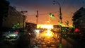 Abstract image through wet car windshield on movng transport and autuomobiles in rain at sunset rays Royalty Free Stock Photo