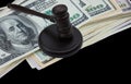 Abstract photo with wooden gavel and american dollars isolated on black background