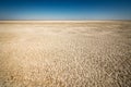 An abstract photograph of the dry and cracked earth of the Etosha Pan against a deep blue sky